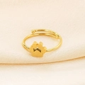 Detailed close-up of golden adjustable cat paw ring on beige silk background - US 6