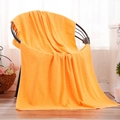 Bright orange microfiber bath towel with embossed bear design draped over a chair - 150g Embossed 70*140 / Orange Yellow
