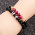 Detail eines Perlenarmband-Sets mit mattschwarzen Perlen, rosa Steinen und Goldkronen - Set 2 (Pfirsichglanz/Mattschwarz/Gold Silber Krone)