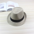 Atmungsaktiver Strohhut-Fedora in Hellkhaki mit schwarzem Band auf Holzhintergrund - Einheitsgröße / Aprikose