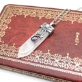Macro detail of white crystal pendant with ornate silver filigree and purple gemstone - White Crystal