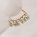 Détail de boucles d'oreilles à franges dorées avec gemmes vert clair sur tissu blanc - Style 02 KC Or Vert Clair (3795)