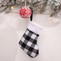 Detail of a black and white plaid Christmas stocking with a snowflake knit ball ornament - Small / Black White Grid