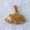 Detailed view of a golden hedgehog pendant with textured quills and a small rhinestone eye - Hedgehog / Gold
