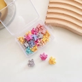 Close-up of mini crown-shaped hair claws in assorted macaron colors with storage box - 3-Crown 20pcs Mixed Colors