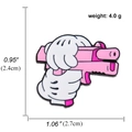 Pin's émaillé pistolet rose avec dimensions et poids sur fond blanc pur - Main Tenant un Pistolet Rose