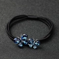 Elastic black hair tie featuring two faceted blue crystal butterflies on a textured background - Blue Double Butterfly