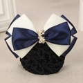 Detailed close-up of hairnet featuring navy blue and beige bow with golden floral buckle - Willow Leaf Beige + Blue