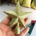Close-up of a golden glitter star tree topper held by hand for Christmas decor - 10cm Gold