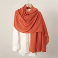 Detailed texture of soft orange linen scarf paired with a white shirt for women - Orange Red