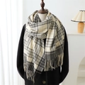 Dettaglio di una sciarpa beige a quadri con frange indossata su un cappotto nero - 200cmX60cm / Nero