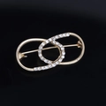 Elegant gold infinity shaped brooch pin featuring clear rhinestones on a black background - Figure 8/Infinity Style (YNCP04804) / Gold