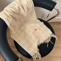 Beige plaid scarf with pink embroidered heart and tassels draped on a chair - Small Blue Beige