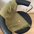 Bufanda de cuadros verdes con bordado de corazón amarillo y flecos en una silla - Corazón Pequeño Verde Oscuro