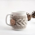 Macro detail of beige crochet mug sleeve with cable knit pattern and wooden button decor - Beige with Button