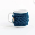 Close-up of handmade dark blue crochet mug sleeve with button detail on white ceramic mug - Sky Blue with Button