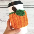 Detail showing a handmade crochet pumpkin mug sleeve in orange yarn with leaf decor - Orange Pumpkin
