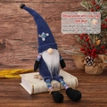 Dark blue plush Christmas gnome with long striped legs sitting on white books - Dark Blue