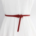 Slanke rode kunstleren knoopriem voor dames gestyled op een witte geplooide jurk - 100cm / Rood