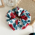 Dettaglio dell'elastico scrunchie in tessuto con rose rosse e foglie su fondo bianco - Bianco