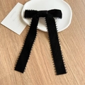 Detalle de un lazo para el pelo en terciopelo negro con cintas largas y encaje - Estilo de Terciopelo Negro / Negro