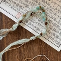 Close-up of Bohemian necklace with green silk ribbon, natural stone beads and wood accents - Light Green Ribbon Wood Turquoise Style