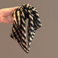 Pince à cheveux à carreaux rouges et beige avec grand nœud papillon en main - Carreaux Noirs