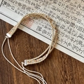 Detail of bohemian handmade woven belt with evil eye charm on vintage calligraphy background - Light Beige Tassel Opal Decor Style
