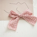 Detailaufnahme einer rosa karierten Stoff-Haarspange mit Schleife - Rosa
