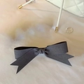 Detail view of a gray satin bow hair clip with dovetail ends on soft white fabric - Single Piece / Gray