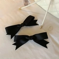 Pair of elegant black satin bow hair clips in a high-end lifestyle setting on fabric - Single Piece / Black
