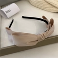 Detalle de la diadema de tela beige con lazo grande y textura suave de calidad - Café con Leche