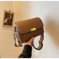 Detail van bruine leren crossbodytas met een brede schouderband met patronen - Bruin