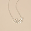 Macro detail of silver stethoscope heart pendant with a polished stainless steel finish - Silver