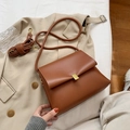 Sac bandoulière vintage en cuir marron avec boucle dorée mate sur trench beige - Marron Jaune