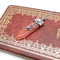 Detail view of hexagonal rose quartz pendant with silver sword pattern and purple stone - Watermelon red