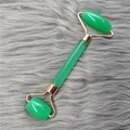 Dual-head green facial roller with rose gold metal frame on grey fur background - Green Roller