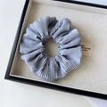 Detailed view of light gray-blue pleated fabric scrunchie with soft ribbed texture - Pleated Blue