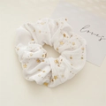 Primer plano de coletero de terciopelo blanco con estrellas doradas y textura suave - Colección Estrella / Blanco