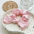 Detalle de coletero de satén rosa con lazo decorativo en un elegante plato cerámico - Rosa Sakura