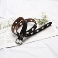 Ceinture punk en cuir noir avec œillets argentés et boucle ardillon sur fond de livre - Ceinture Seule