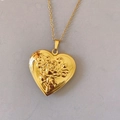 Detalle de medallón de corazón dorado con relieve de rosa y cadena de clavícula - Oro rosa
