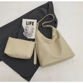 Detail of beige PU leather bucket bag set with matching pouch on a grey blazer and magazine - Shoulder Bag Set / Off White