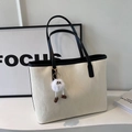 Off-white tote bag with black trim and a playful white plush monster charm - With Charm / Off White