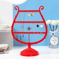 Red trophy-shaped jewelry stand organizer for necklaces and earrings in a modern home setting - Red