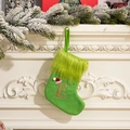 Calza di Natale in maglia verde con lettera E glitterata dorata appesa al camino decorato - Lettera E
