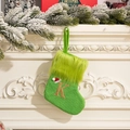 Green knit Christmas stocking with golden letter K embroidery and festive plush trim - Letter K