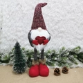 Christmas gnome doll with heart and long red knit hat on snowy festive background - Red