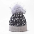 Close-up of sparkling silver sequins and a fluffy grey faux fur pompom on a winter knit beanie - One Size / Grey (Dyed Pom Pom)