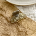 Detail shot of a heart-shaped acetate hair claw clip on brown paper background - Marble Gray